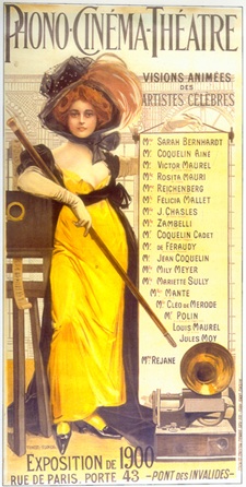 Illustration d'une femme aux cheveux roux portant un grand chapeau, une robe jaune descendant jusqu'aux chevilles et des talons hauts. Elle tient une longue matraque et s'appuie contre un projecteur de cinéma. Un gramophone est posé à ses pieds. En haut de l'illustration, on peut lire "Phono-Cinéma-Théâtre". Le texte à gauche de la femme indique "Visions Animées des Artistes Celebres", suivi d'une liste d'interprètes.