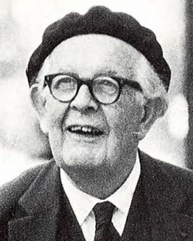Photo d'un homme aux cheveux blancs et portant des lunettes, en costume