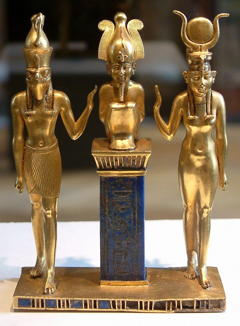 Osiris sur une colonne de lapis-lazuli au centre, flanqué d'Horus à gauche et d'Isis à droite, entre 874 et 850 av. J.-C., Louvre