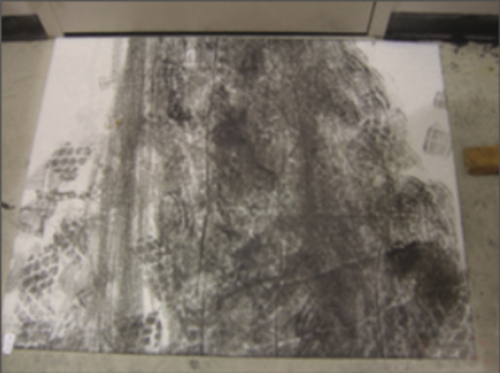 Un tapis blanc sur un sol largement souillé d'empreintes de pas couleur suie