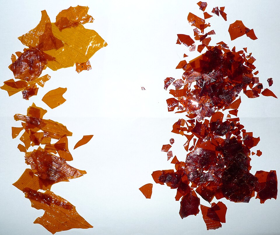 Gros plan des paillettes de gomme laque Waxy #1 Orange (à gauche) et Dewaxed Bona (à droite). La première, la gomme laque orange, est la gomme laque traditionnelle utilisée depuis des siècles pour la finition des panneaux muraux en bois et des armoires de cuisine.