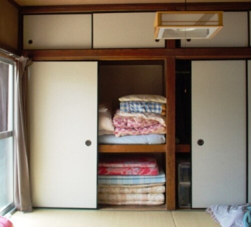 Futons rangés dans un oshiire, dans un washitsu (pièce traditionnelle japonaise) au sol en tatami