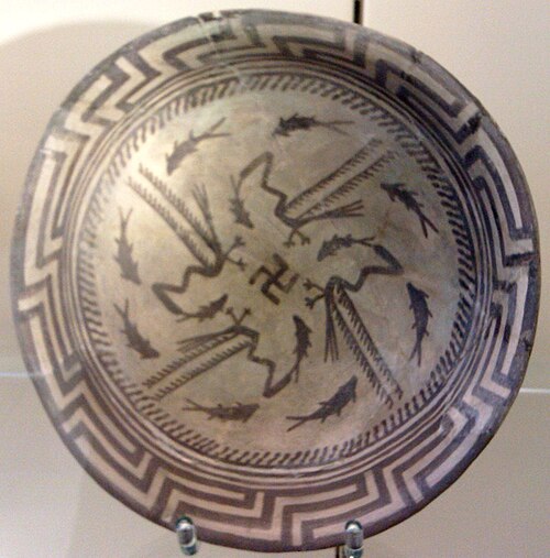 Assiette Samarra, avec un motif composé d'un bord, d'un cercle de huit poissons et de quatre poissons nageant vers le centre attrapés par quatre oiseaux, au centre se trouve un symbole de croix gammée ; vers 4000 av. J.-C. ; céramique peinte ; diamètre : 27,7 cm ; Vorderasiatisches Museum (Berlin)