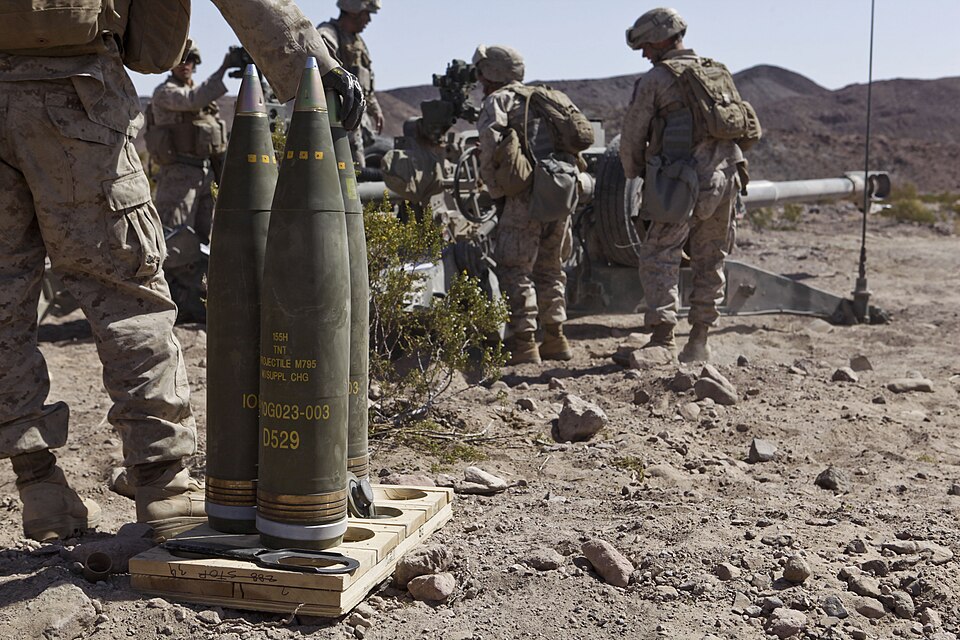 Obus d'artillerie M795 avec fusées, portant une étiquette indiquant leur charge de TNT.