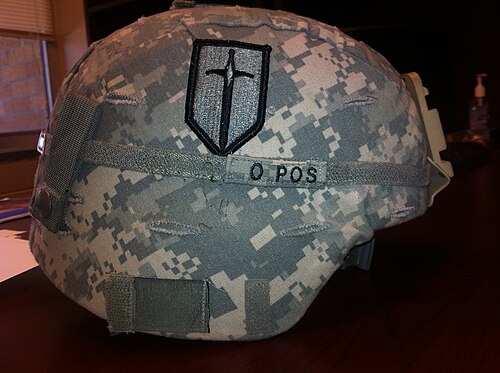 Insigne à demi-échelle de la 1ère brigade d'amélioration des manœuvres porté sur le côté droit d'un casque de combat avancé.