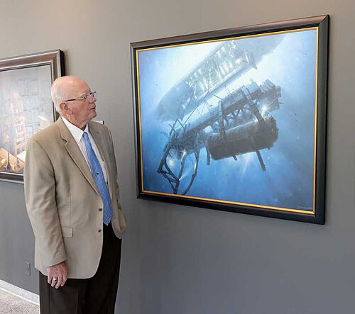 Sherman Wetmore, ingénieur en chef du Glomar Explorer, regarde une peinture à l'huile du navire soulevant le sous-marin soviétique.