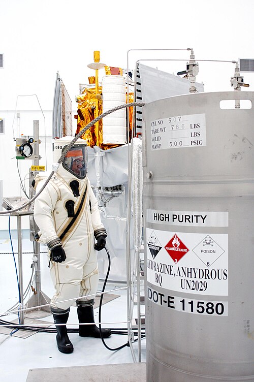 Un ouvrier en costume surveille l'approvisionnement en carburant d'hydrazine à charger dans le MESSENGER.