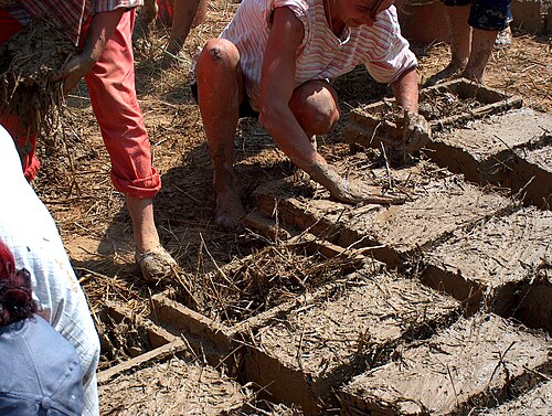 Mélange de boue et de paille dans des cadres en briques
