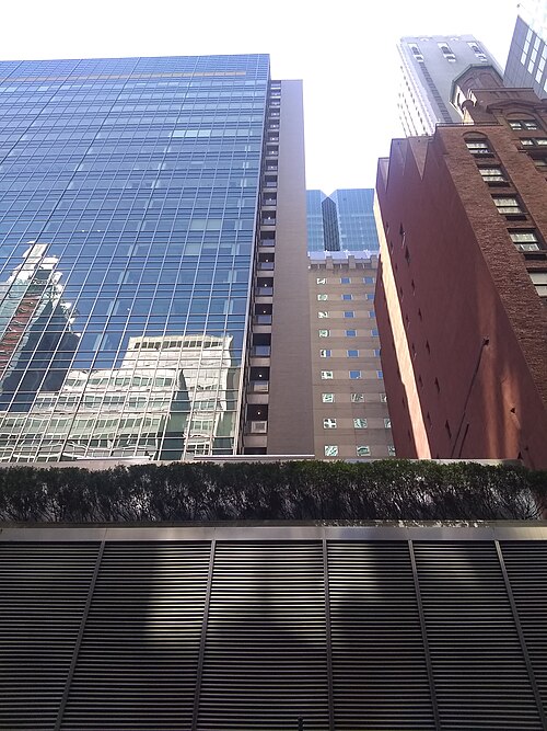 La façade vue depuis la 54e rue. La plus grande partie de la façade est en verre vert, mais une « colonne vertébrale » en maçonnerie est visible au centre à droite.