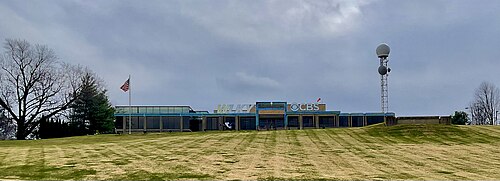 Un exemple d'héliport incliné (à droite) sur la propriété de WLKY, une station de télévision de Louisville, dans le Kentucky, pour permettre à son hélicoptère d'information d'atterrir sur ce qui est par ailleurs une colline escarpée en pente descendante vers le front de la rivière Ohio en contrebas.