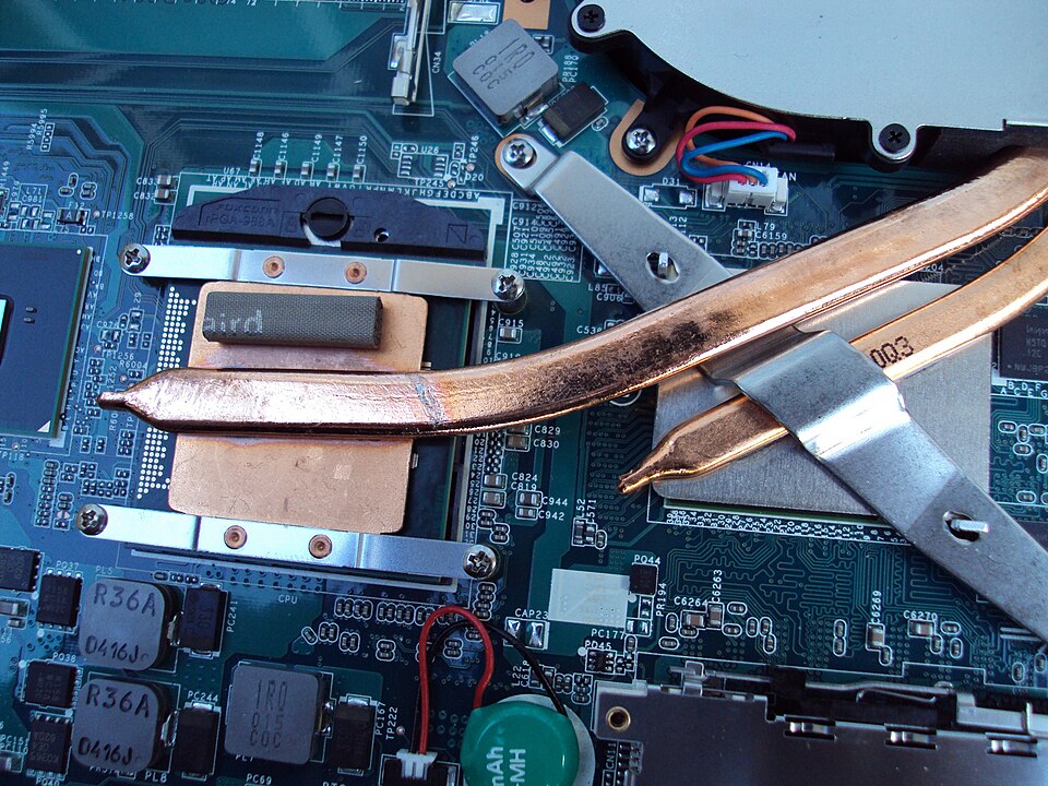 Les dissipateurs thermiques du processeur et de la carte graphique d'un ordinateur portable, ainsi que les caloducs en cuivre transférant la chaleur à un ventilateur d'extraction qui expulse l'air chaud.