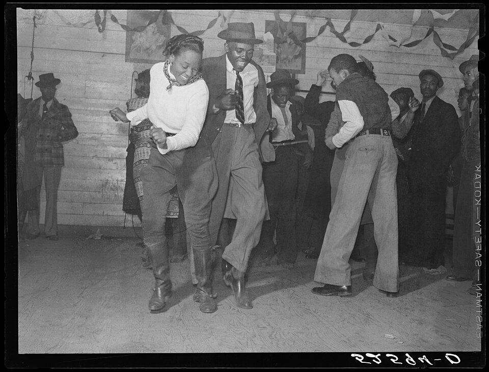 Danse sociale – les danseurs d'un juke joint dansent le Jitterbug, une danse du début du XXe siècle qui influencera plus tard le swing, le jive et le jazz.