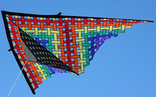 Un cerf-volant triangulaire coloré contre un ciel bleu