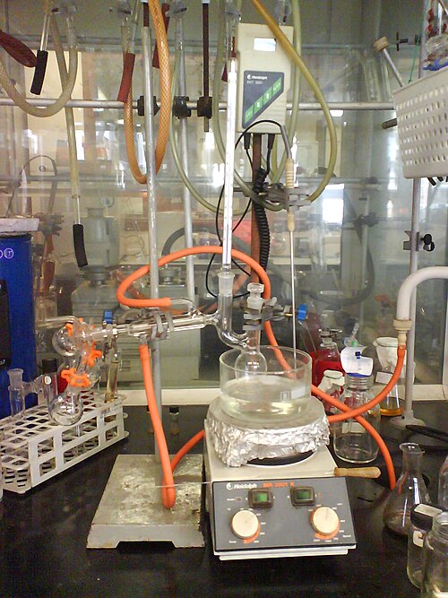 Distillation à l'aide d'un appareil semi-micro. La conception sans jointure élimine la nécessité d'assembler les pièces. Le ballon en forme de poire permet d'éliminer la dernière goutte de résidu, contrairement à un ballon rond de taille similaire. Le faible volume de rétention évite les pertes. Un "cochon" est utilisé pour canaliser les différents distillats dans trois ballons récepteurs. Si nécessaire, la distillation peut être effectuée sous vide à l'aide de l'adaptateur de vide situé sur le cochon.