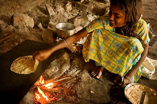 Une fille prépare des chapatis de manière traditionnelle
