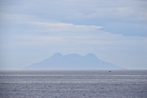 Silhouette du mont Timpoong (à gauche) et du mont Mambajao (à droite), les plus hauts sommets de la plus grande montagne de Camiguin, vus du nord, à travers la mer de Bohol
