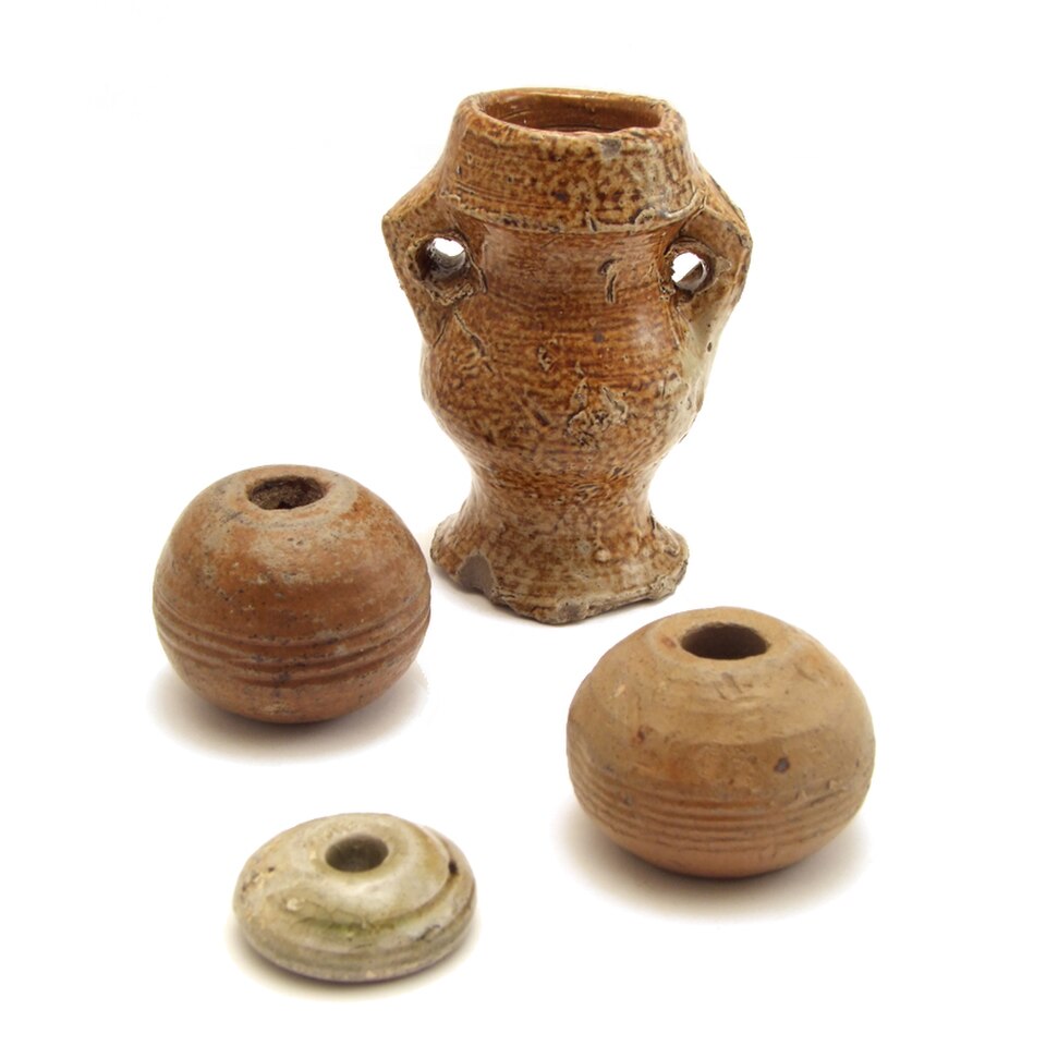 Cruche à filer médiévale contenant de l'eau ou de la graisse à utiliser pendant le processus de filage et 3 fusaïoles médiévales.