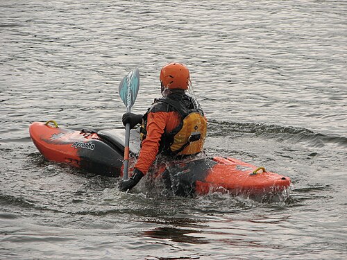Kayakiste remontant d'un rouleau sur eau plate