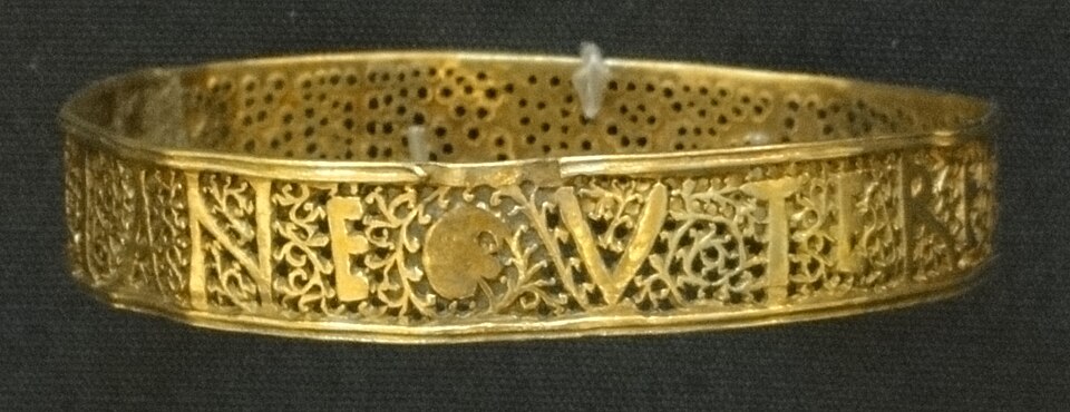 Un bracelet en or orné de motifs et d'inscriptions réalisés en perçant des trous dans le bracelet.