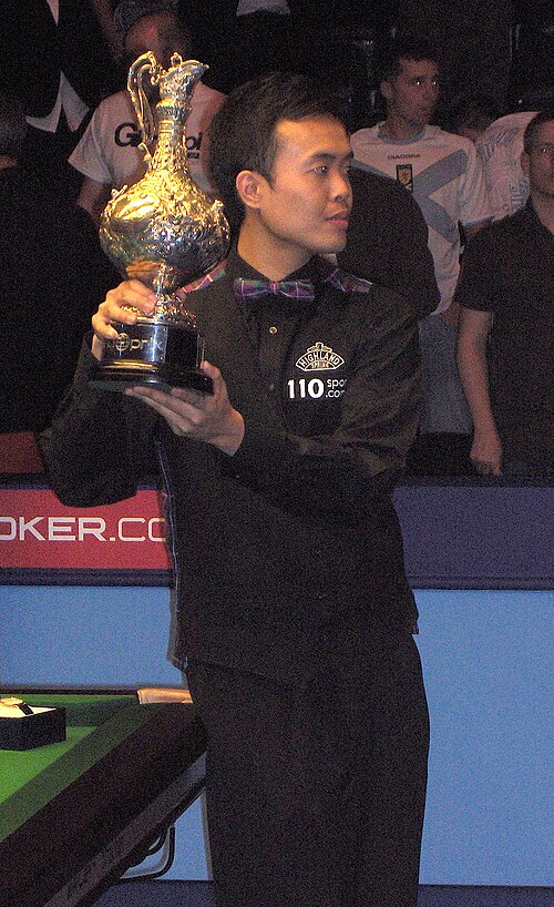 Photographie de Marco Fu debout tenant le trophée du Grand Prix