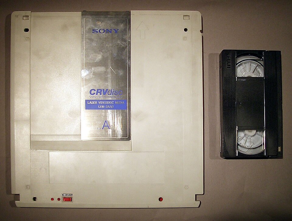 Un disque CRV avec une cassette VHS pour comparaison de taille
