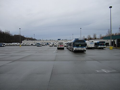 Un grand parking pavé avec des bus garés en rangées