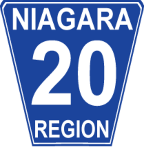 Borne routière régionale de Niagara 20. Bien que Niagara soit généralement conforme à la conception standard de « pot de fleurs » de l'Ontario, les bornes sont blanches sur bleu plutôt que noires sur blanc plus traditionnelles et ont des coins arrondis.