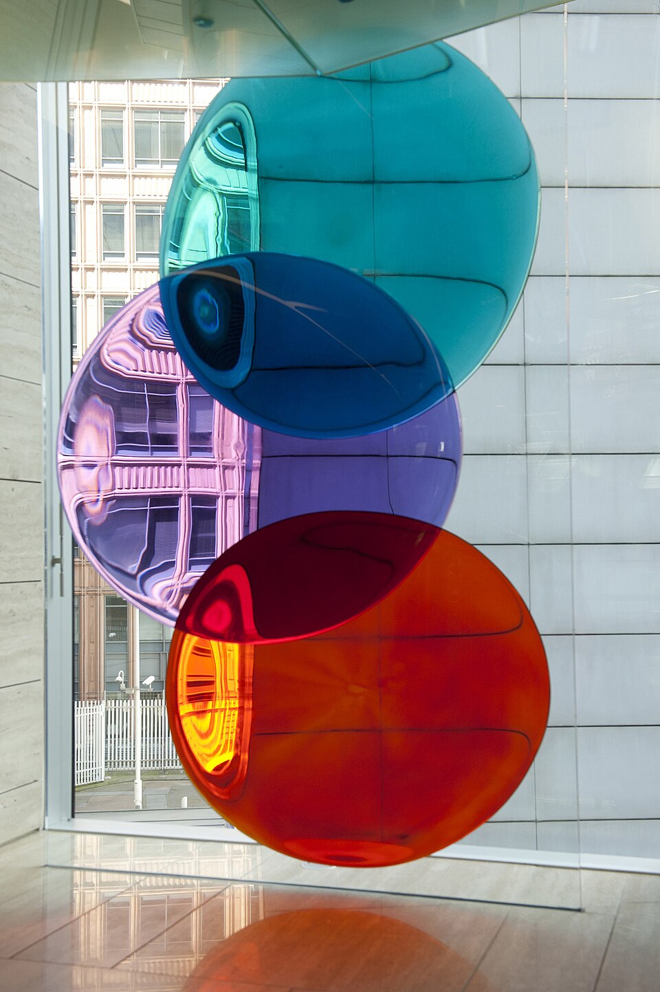 Trois disques de verre, l'un turquoise, l'autre violet et le troisième rouge.