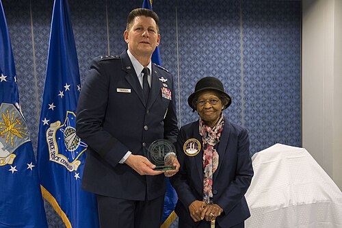 Le commandant des forces spatiales de l'armée de l'air remet un prix à Gladys West lors de son intronisation au Temple de la renommée des pionniers de l'espace et des missiles de l'armée de l'air pour ses travaux sur le GPS, le 6 décembre 2018.