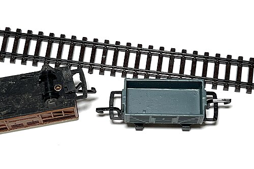 Wagon de marchandises Treble-0-Lectric avec un attelage à verrouillage de tension miniaturisé à côté de la voie Arnold à l'échelle N.