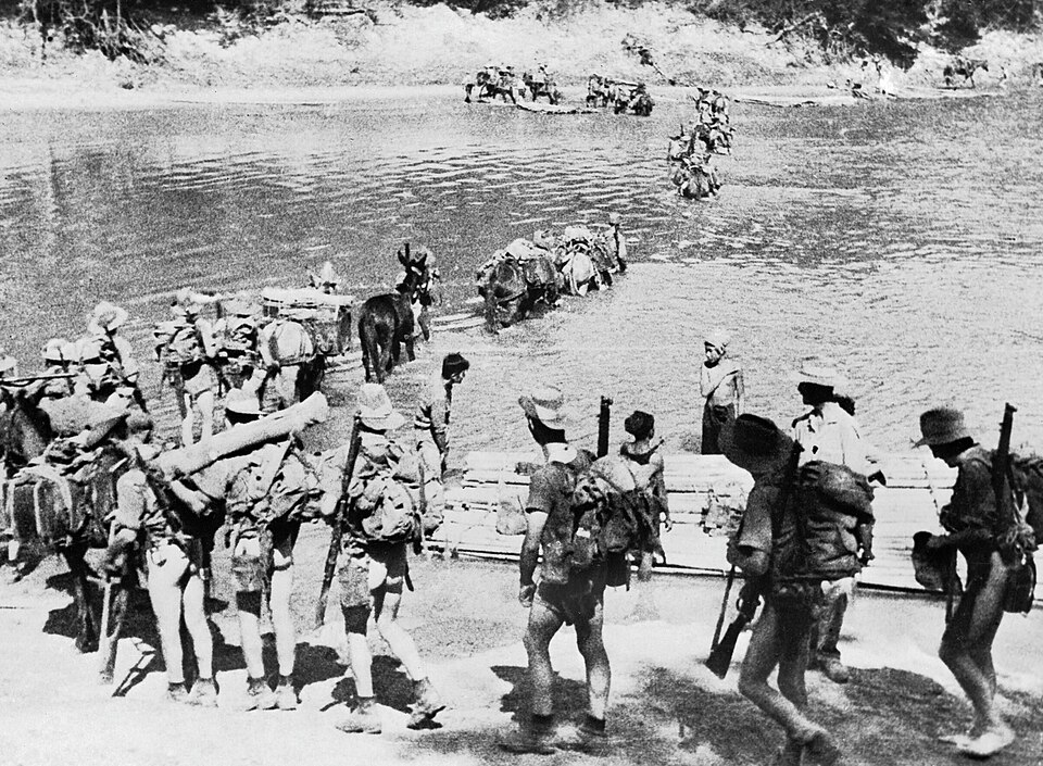 Des forces spéciales britanniques Chindit, transportant leurs armes et leur équipement, progressent sur une rivière en Birmanie.