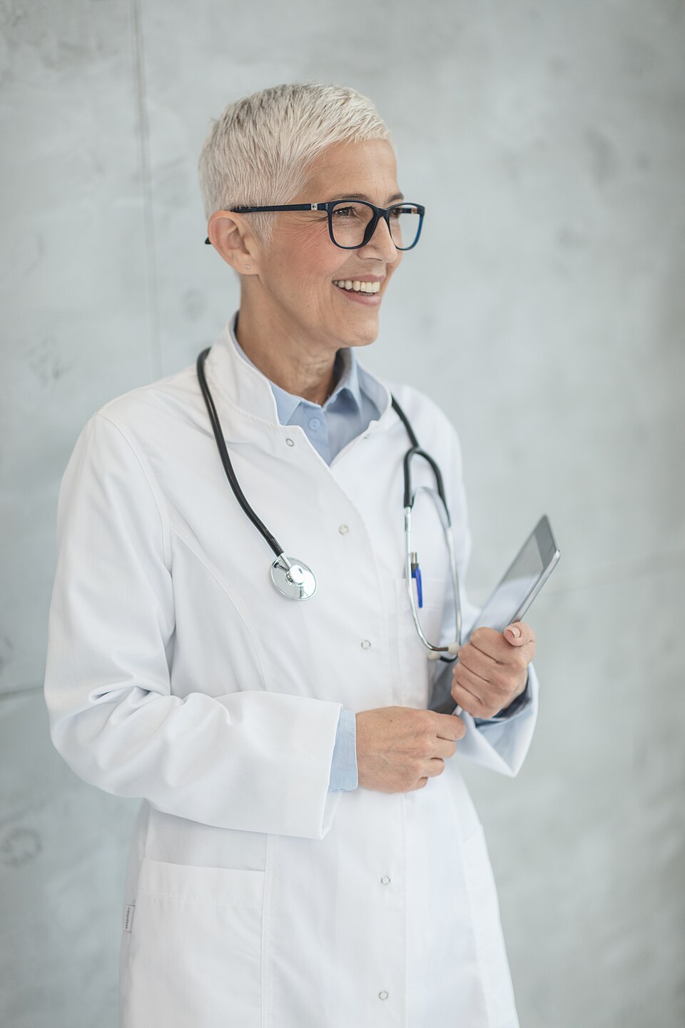 Photo d'une femme médecin aux cheveux blancs et portant des lunettes