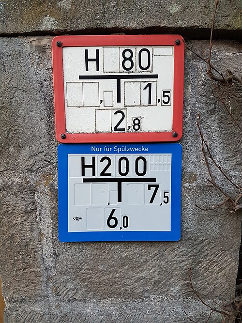 Plaque de balisage rouge pour bouche d'incendie en Allemagne, ainsi qu'une autre plaque de balisage bleue à usage spécial pour bouche d'incendie - Les chiffres indiquent le diamètre (80 mm) et l'emplacement (2,8 mètres à l'arrière, 1,5 mètre à droite).