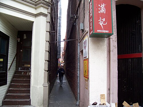 Photographie d'une ruelle avec un homme qui la traverse