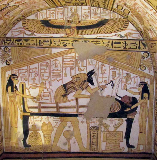 Fresque d'une momie couchée sur un cercueil. Des femmes se tiennent debout à la tête et au pied du cercueil, tandis qu'une femme ailée est agenouillée dans le registre au-dessus