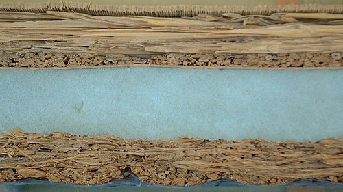 Coupe transversale d'un tatami avec un noyau caché en polystyrène extrudé et des couches supérieures et inférieures d'igusa traditionnel (jonc commun)