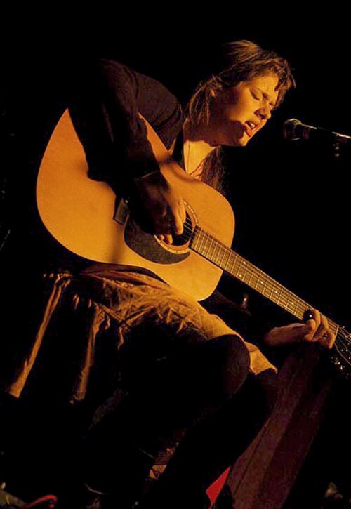 Adele joue de la guitare acoustique