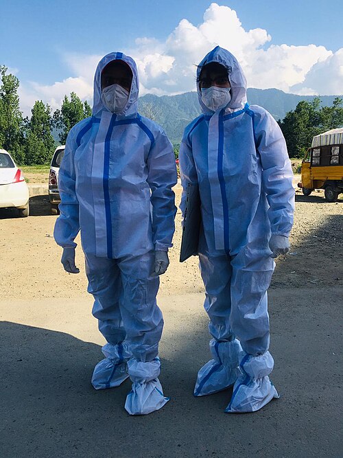 Deux ambulanciers portant des blouses médicales EPI à l'extérieur.