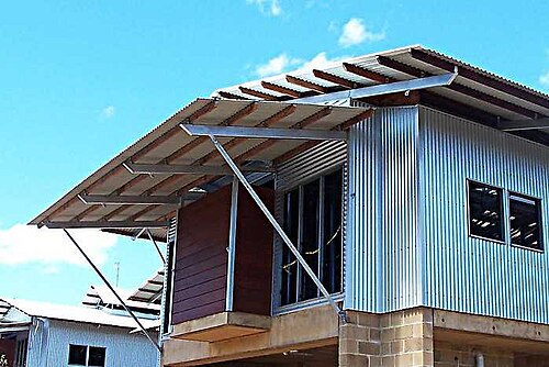 Pannes en bois dur fixées sur des supports en acier sur un toit à pignon et un toit principal. Maison en construction, Australie du Nord tropicale.