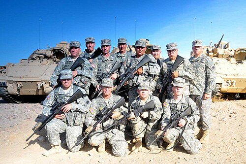 Les troupes de la réserve militaire de l'État de Californie armées de M16 avec 3 Bradleys derrière elles ont pris une photo pendant qu'elles suivaient une formation à la sécurité de la base.