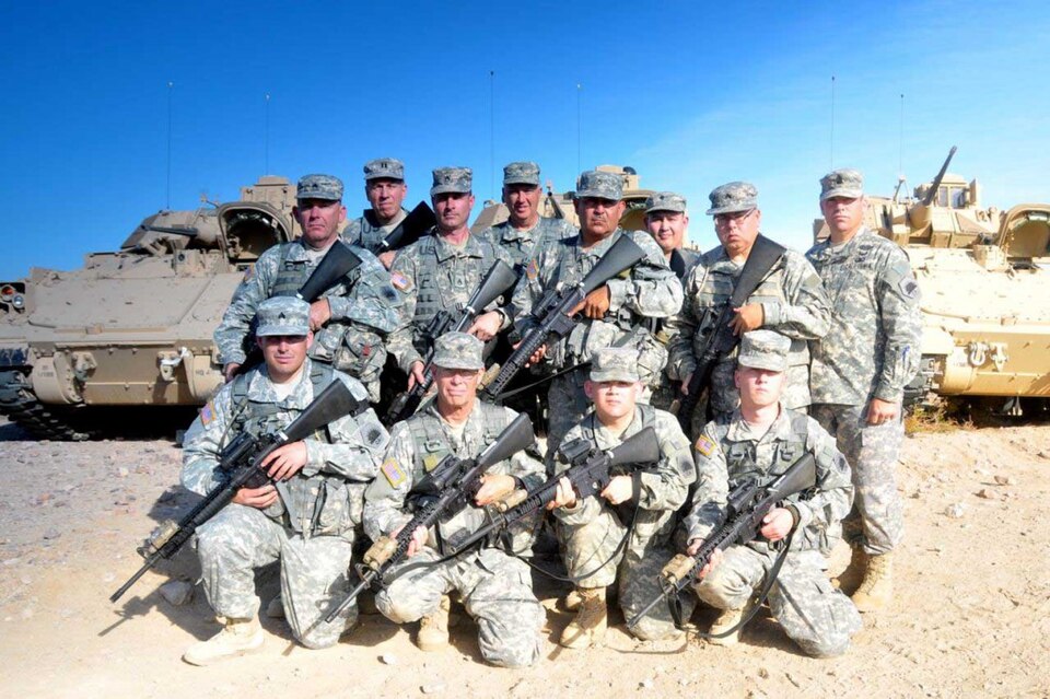 Les troupes de la réserve militaire de l'État de Californie armées de M16 avec 3 Bradleys derrière elles ont pris une photo pendant qu'elles suivaient une formation à la sécurité de la base.