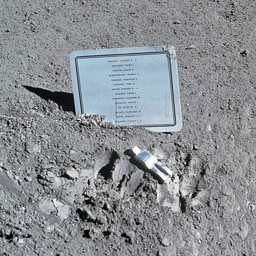 Une petite statue en aluminium et une plaque sur la surface lunaire
