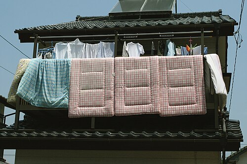 Des futons suspendus pour aérer sur un balcon
