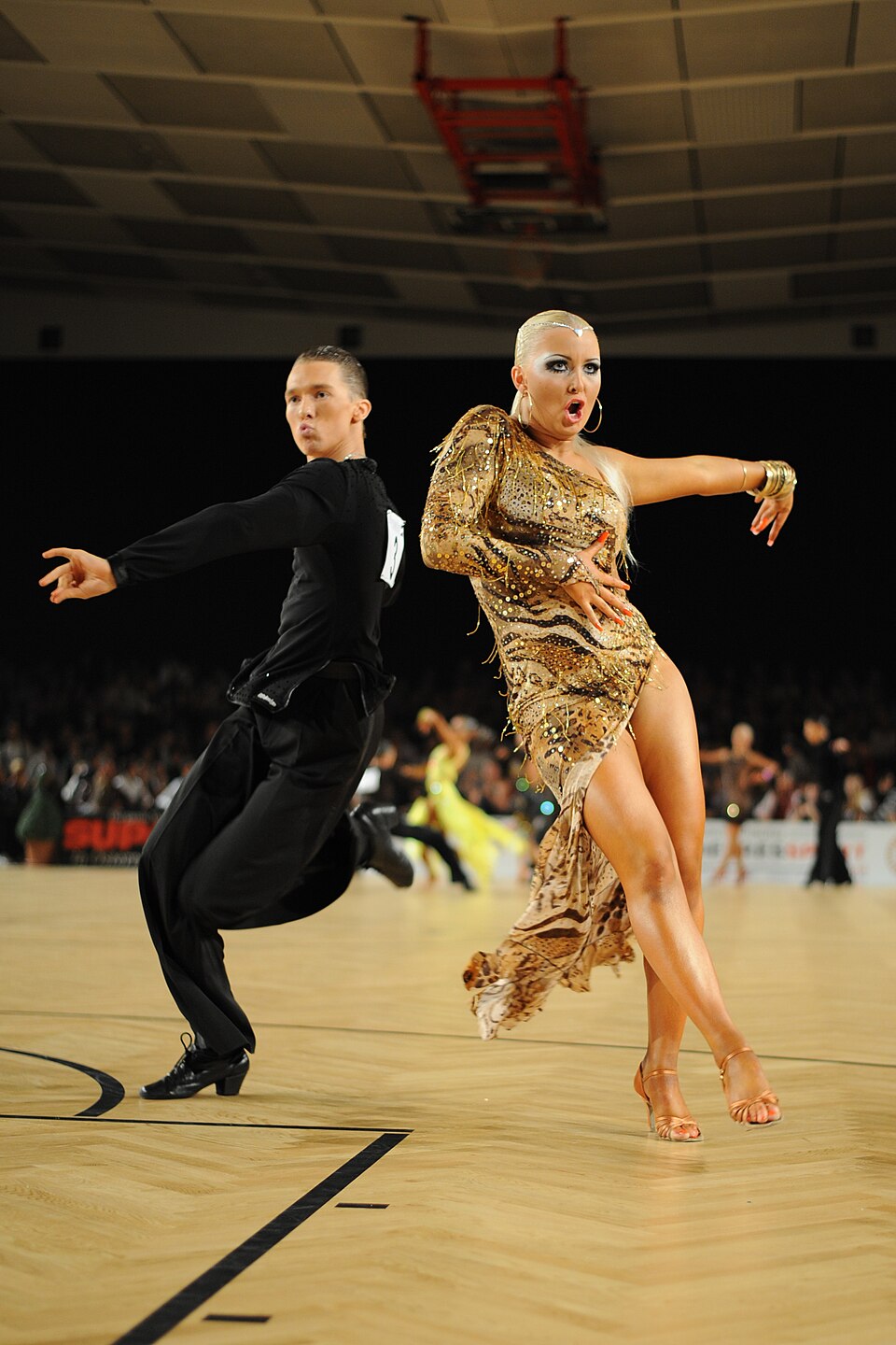 Un couple de danseurs de salon latins exécute une samba lors d'une compétition de danse sportive.