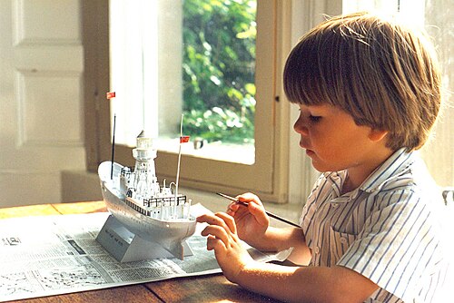 Un garçon de 4 ans peint une maquette en plastique Revell du bateau-phare South Goodwin
