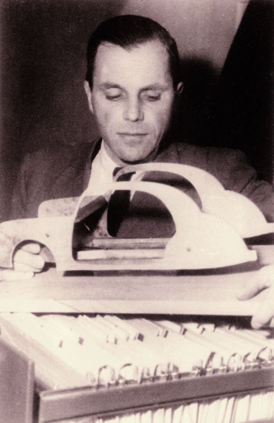 Béla Barényi tenant un modèle de voiture