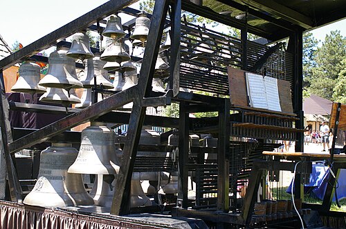 Un petit cadre en métal avec des cloches et un clavier de carillon attachés.