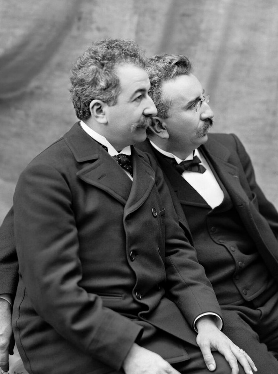 Les frères Auguste et Louis Lumière assis regardant vers la gauche