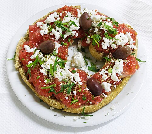 Dakos, entrée traditionnelle crétoise. Paximadi (pain dur) garni de tomates fraîches, de fromage feta, d'origan et d'olives arrosées d'huile d'olive.