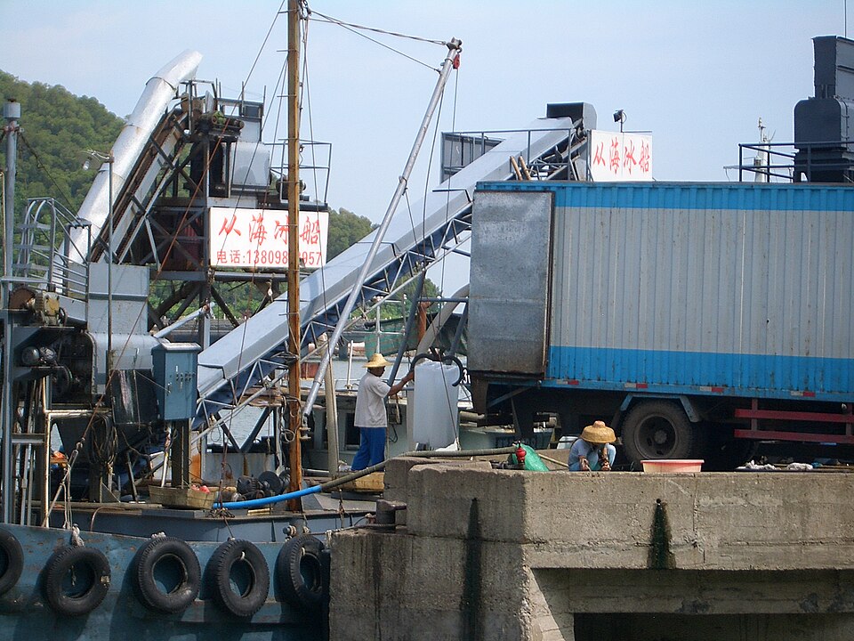Chargement de blocs de glace industrielle d'un camion vers un bateau de dépôt de glace